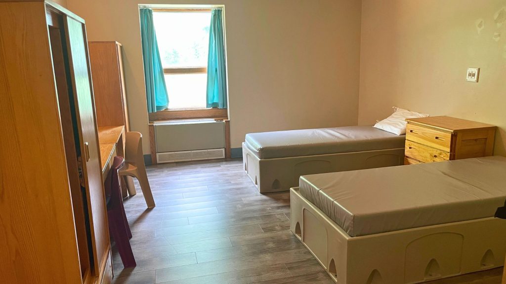 Room with window, beds and dressers
